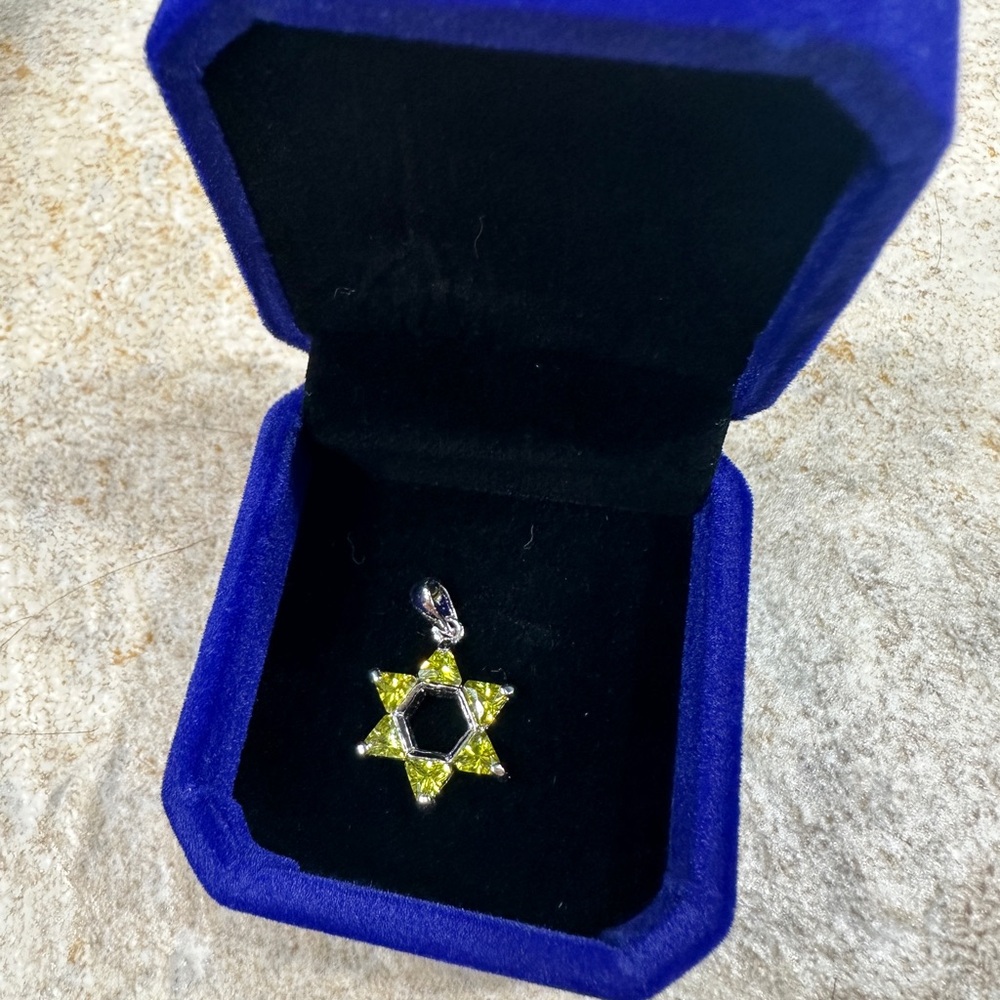 Sterling silver star with six green/peridot stones.